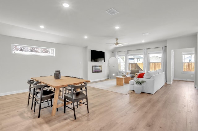 dining room featuring recessed lighting, visible vents, baseboards, light wood finished floors, and a glass covered fireplace