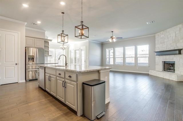 kitchen featuring visible vents, open floor plan, stainless steel appliances, open shelves, and a sink