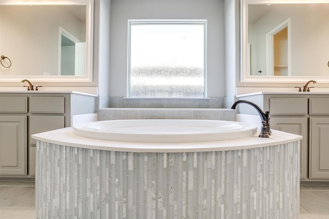 bathroom featuring a garden tub, tile patterned flooring, and vanity