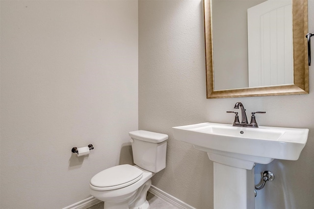 bathroom featuring toilet and baseboards