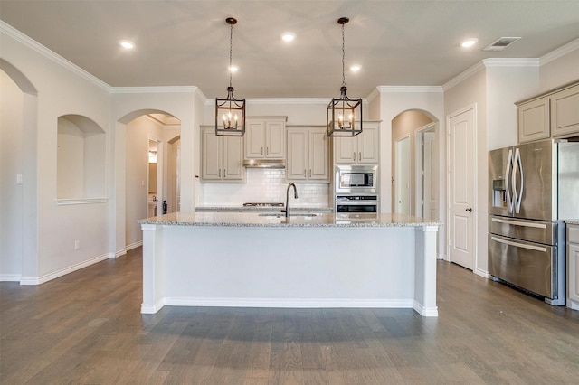 kitchen with stainless steel appliances, dark wood-type flooring, a sink, visible vents, and light stone countertops