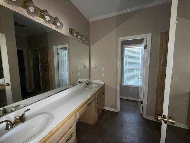 bathroom with double vanity, crown molding, baseboards, and a sink