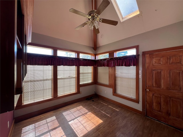 unfurnished sunroom featuring ceiling fan, vaulted ceiling with skylight, and plenty of natural light