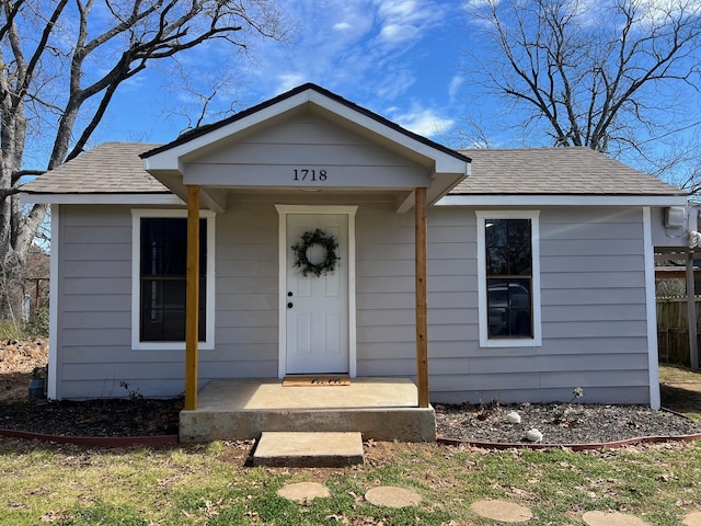 view of front of home with a porch and roof with shingles