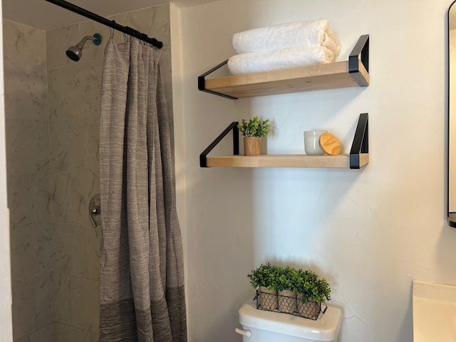 bathroom with a shower stall and toilet