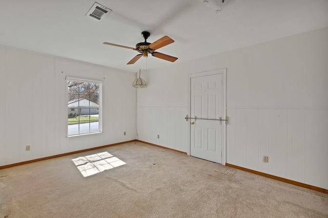 spare room featuring carpet, visible vents, and ceiling fan