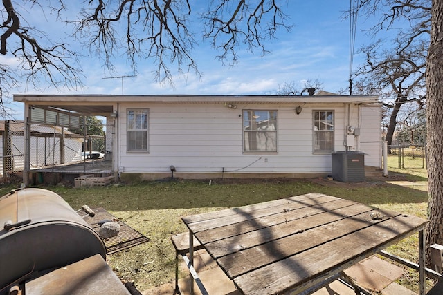 rear view of property with central AC, a lawn, and fence