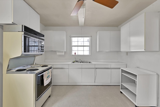 kitchen featuring white cabinets, a ceiling fan, light countertops, light floors, and a sink