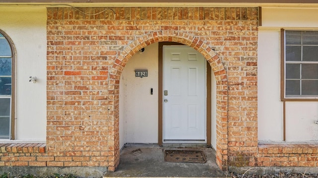 doorway to property with brick siding