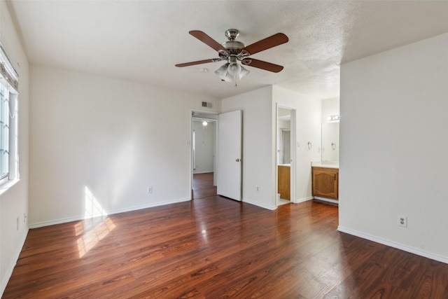 unfurnished bedroom featuring a textured ceiling, wood finished floors, visible vents, and baseboards