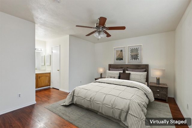 bedroom featuring ceiling fan, dark wood-style flooring, ensuite bath, and baseboards