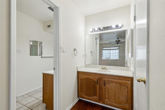 bathroom with ceiling fan, visible vents, vanity, baseboards, and tile patterned floors