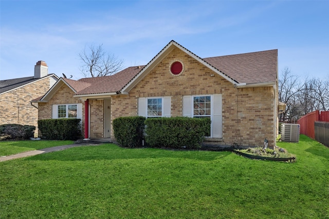 ranch-style home with fence, a front lawn, cooling unit, and brick siding