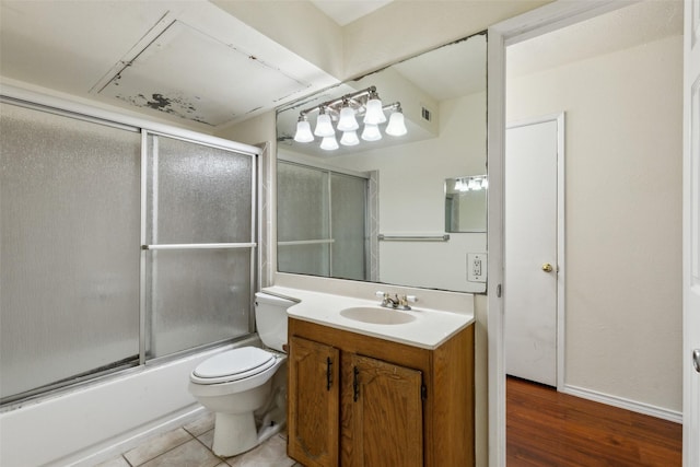 bathroom featuring enclosed tub / shower combo, tile patterned flooring, toilet, visible vents, and vanity