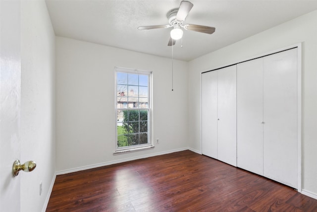 unfurnished bedroom with a closet, wood finished floors, and baseboards