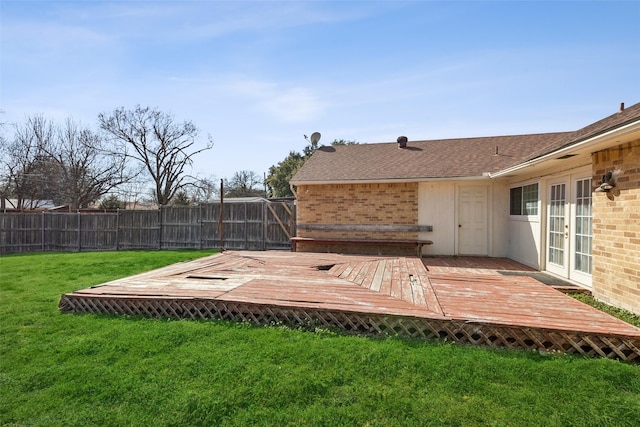 wooden terrace with a yard, french doors, and fence