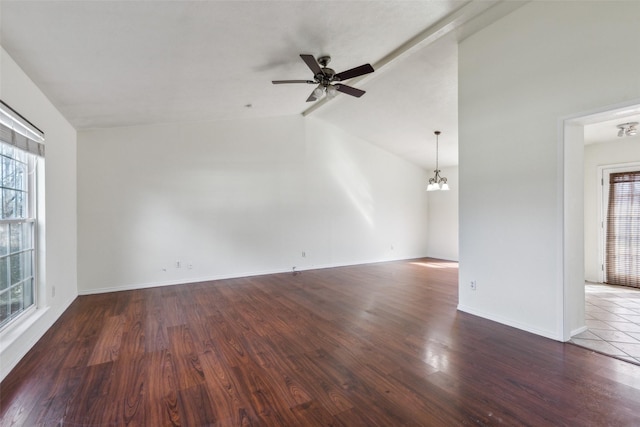 unfurnished room featuring lofted ceiling with beams, ceiling fan with notable chandelier, wood finished floors, and a healthy amount of sunlight