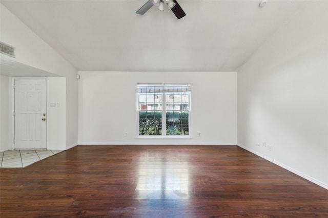 spare room with lofted ceiling, wood finished floors, visible vents, baseboards, and a ceiling fan