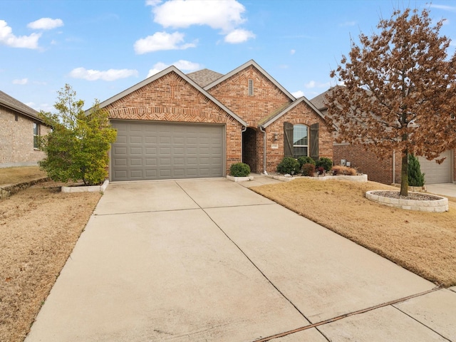 view of front facade featuring driveway, brick siding, and an attached garage