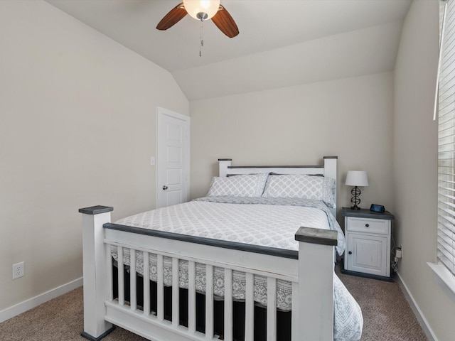 bedroom featuring lofted ceiling, baseboards, dark carpet, and a ceiling fan