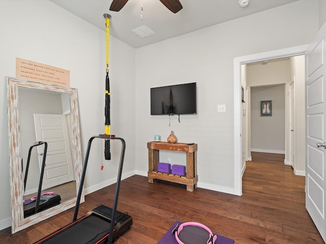 exercise area with dark wood-style flooring, ceiling fan, and baseboards