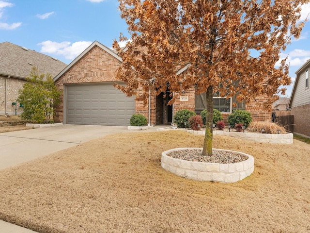 view of property hidden behind natural elements featuring concrete driveway, brick siding, an attached garage, and a front yard