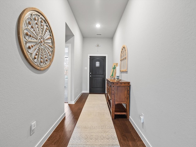 doorway to outside with dark wood-style flooring, visible vents, and baseboards