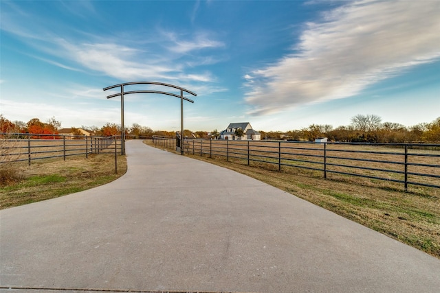 view of community with a rural view and fence