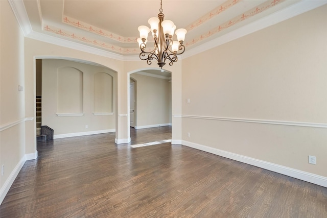 unfurnished dining area featuring arched walkways, baseboards, a raised ceiling, and dark wood-style floors