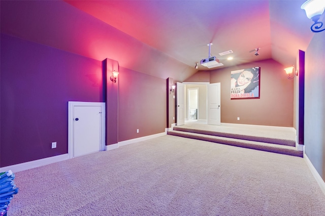 carpeted cinema featuring lofted ceiling, visible vents, and baseboards