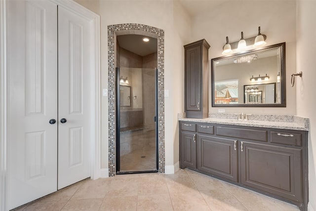 full bath with tile patterned flooring, a shower stall, and vanity