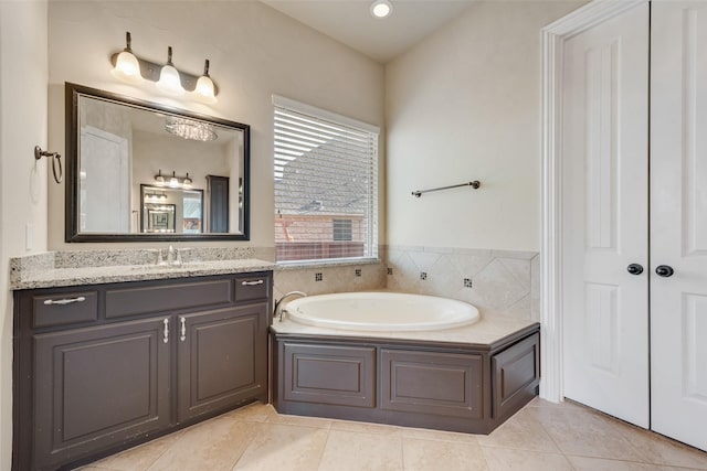 bathroom featuring vanity, a bath, and tile patterned floors