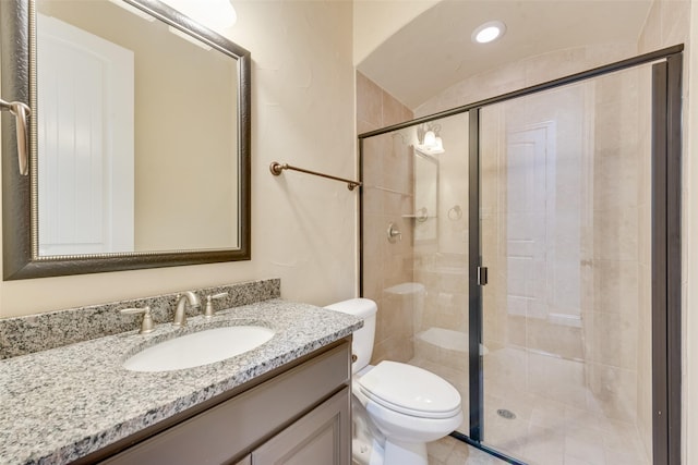 bathroom with toilet, a shower stall, and vanity