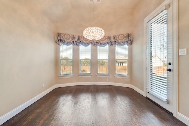 unfurnished dining area with dark wood-style floors, visible vents, and baseboards