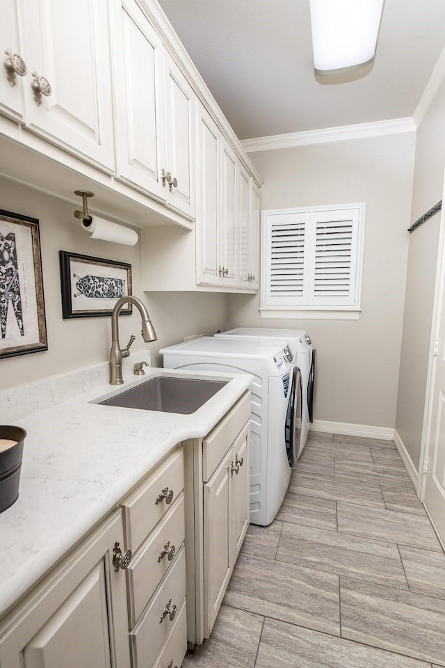 laundry room featuring independent washer and dryer, a sink, cabinet space, and crown molding