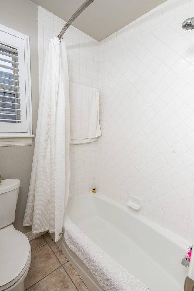 bathroom with shower / bath combo with shower curtain, tile patterned flooring, and toilet