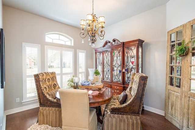 dining room featuring dark wood-type flooring, a notable chandelier, and baseboards