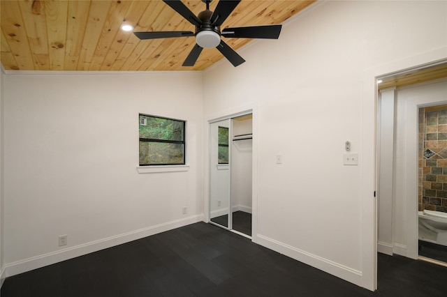 unfurnished bedroom with baseboards, wooden ceiling, dark wood-style floors, vaulted ceiling, and a closet