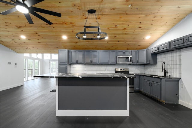 kitchen with a kitchen island, appliances with stainless steel finishes, a sink, and gray cabinetry