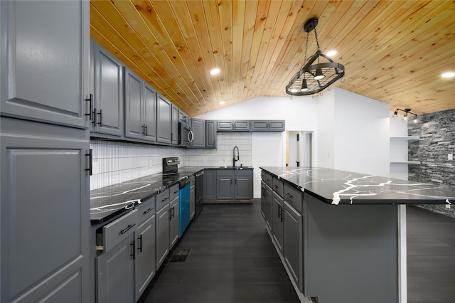 kitchen featuring decorative light fixtures, a sink, stainless steel appliances, gray cabinetry, and backsplash