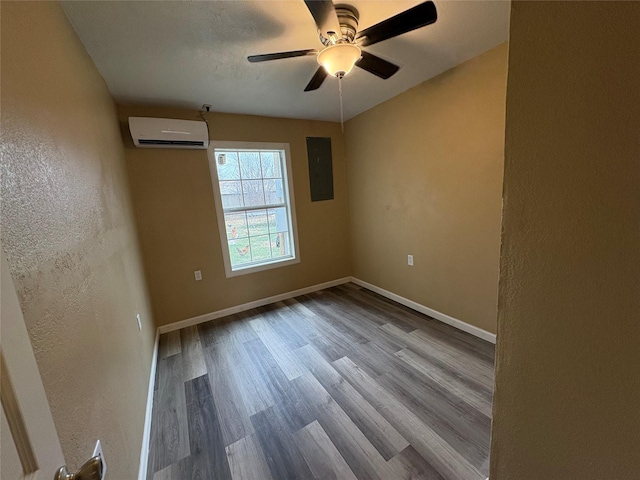 empty room featuring light wood finished floors, a textured wall, a wall mounted AC, electric panel, and baseboards