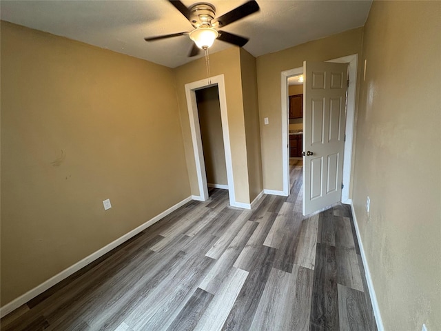 unfurnished bedroom featuring ceiling fan, baseboards, and wood finished floors