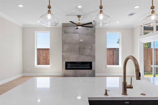 kitchen with crown molding, visible vents, light countertops, and a sink