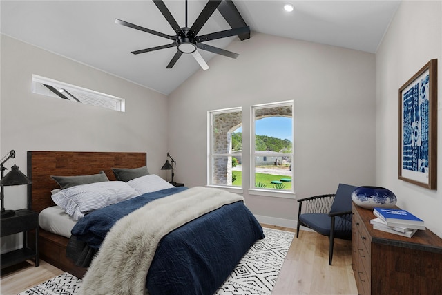 bedroom featuring light wood-type flooring, lofted ceiling with beams, baseboards, and a ceiling fan