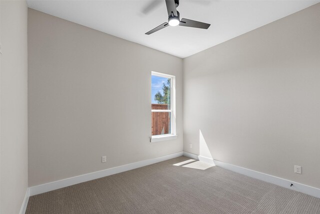 carpeted spare room featuring a ceiling fan and baseboards