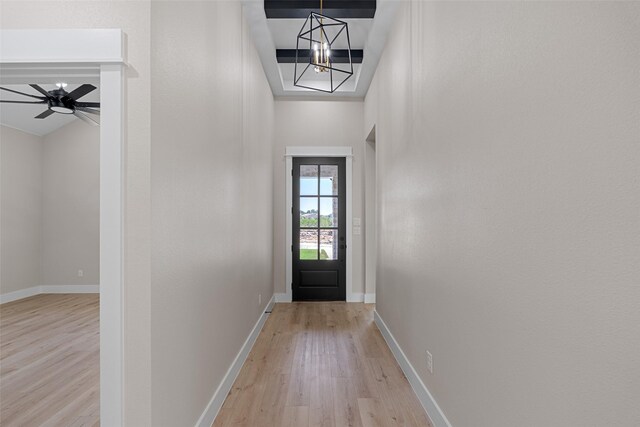 entryway with ceiling fan with notable chandelier, light wood finished floors, and baseboards