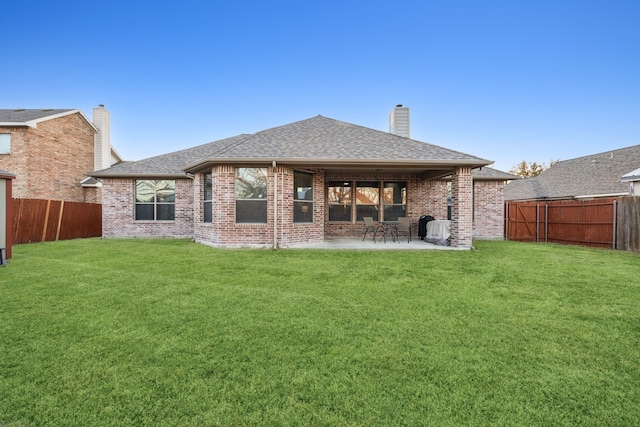 back of house featuring a patio area, a fenced backyard, a lawn, and roof with shingles