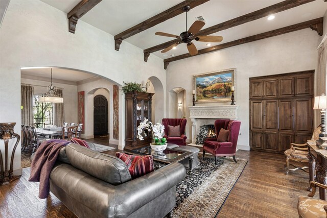 living room with dark wood-style floors, a high ceiling, and beamed ceiling