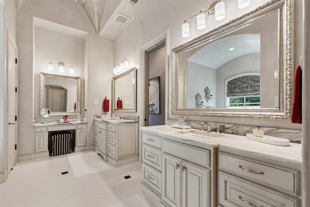 bathroom with lofted ceiling, two vanities, a sink, and visible vents