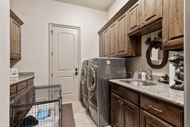 laundry area with crown molding, cabinet space, a sink, and washer and clothes dryer